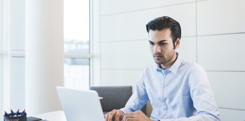 Young indian businessman using computer